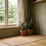 Cosy yoga space with a mat, snake plants, and a salt lamp by a large window overlooking a lush green garden